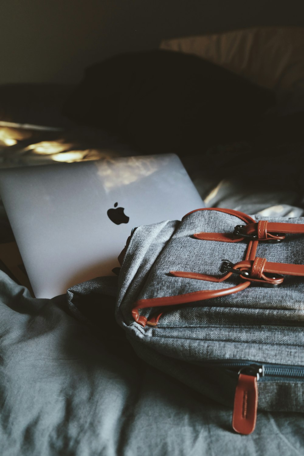 silver MacBook on bed