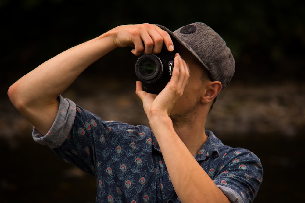 man holding canon camera taking photo