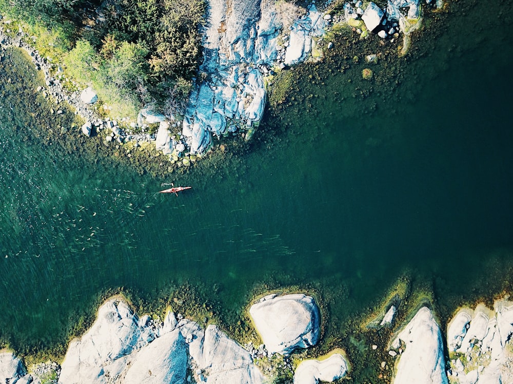 boat on body of water between rocky mountains