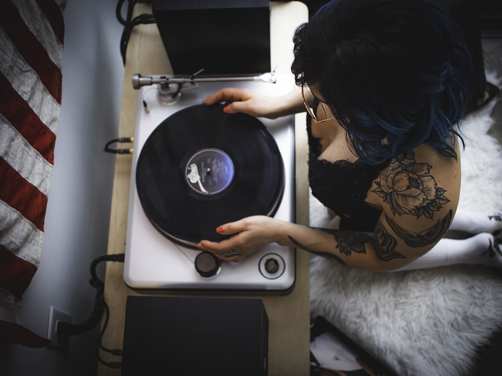 hombre sosteniendo un reproductor de vinilo negro y gris