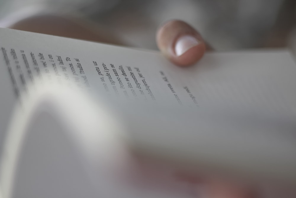 person holding white book