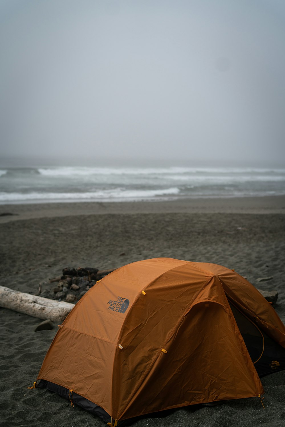 해변 근처 모래에 오렌지 텐트