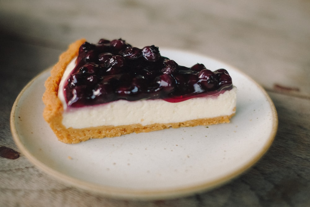 fatie torta de cheesecake de mirtilo no prato de cerâmica branca