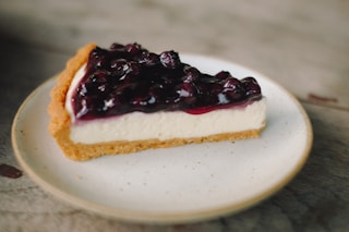 slice blueberry cheesecake pie on white ceramic plate