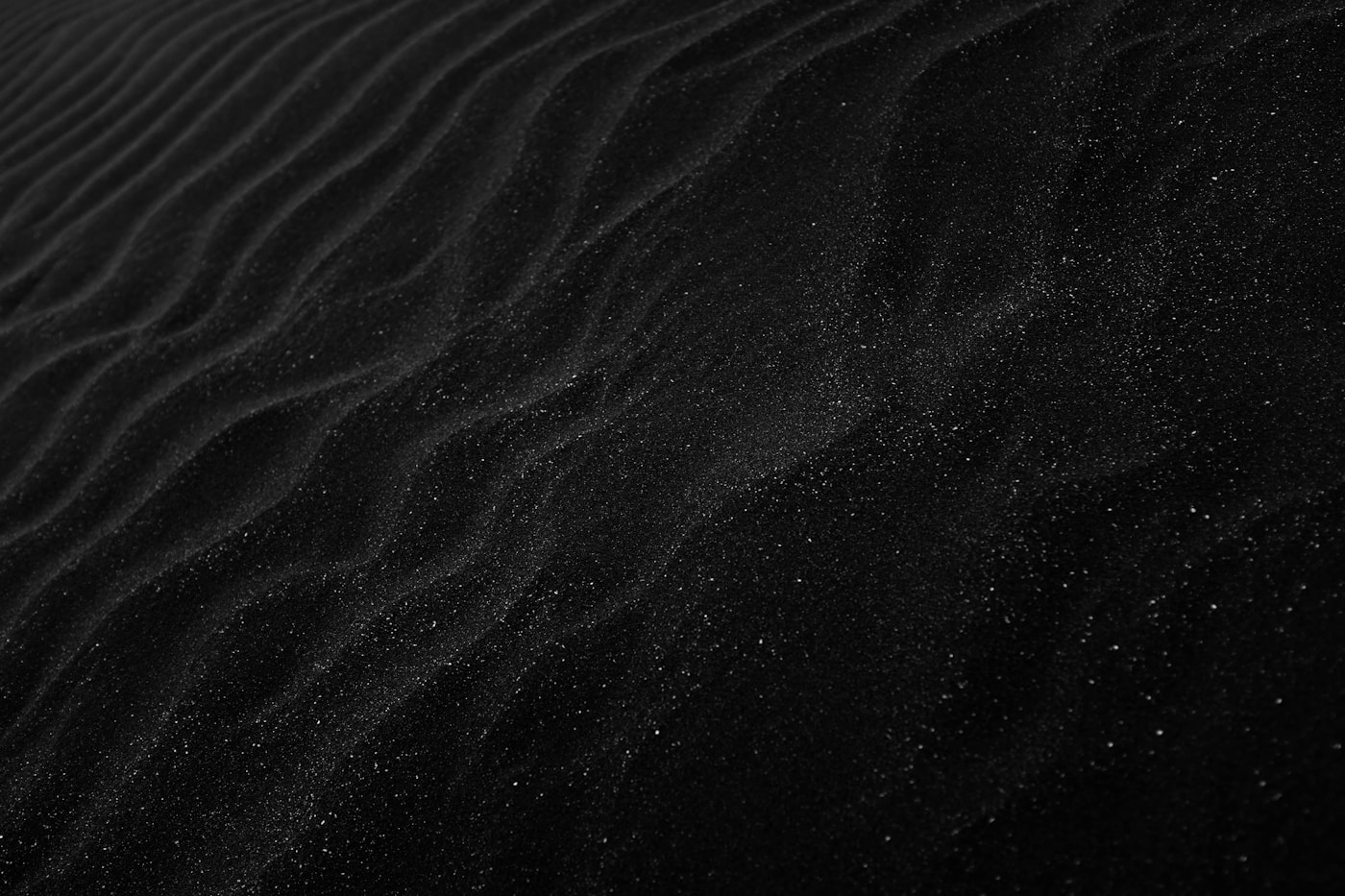 Dark textured sand dunes with dramatic light and shadow