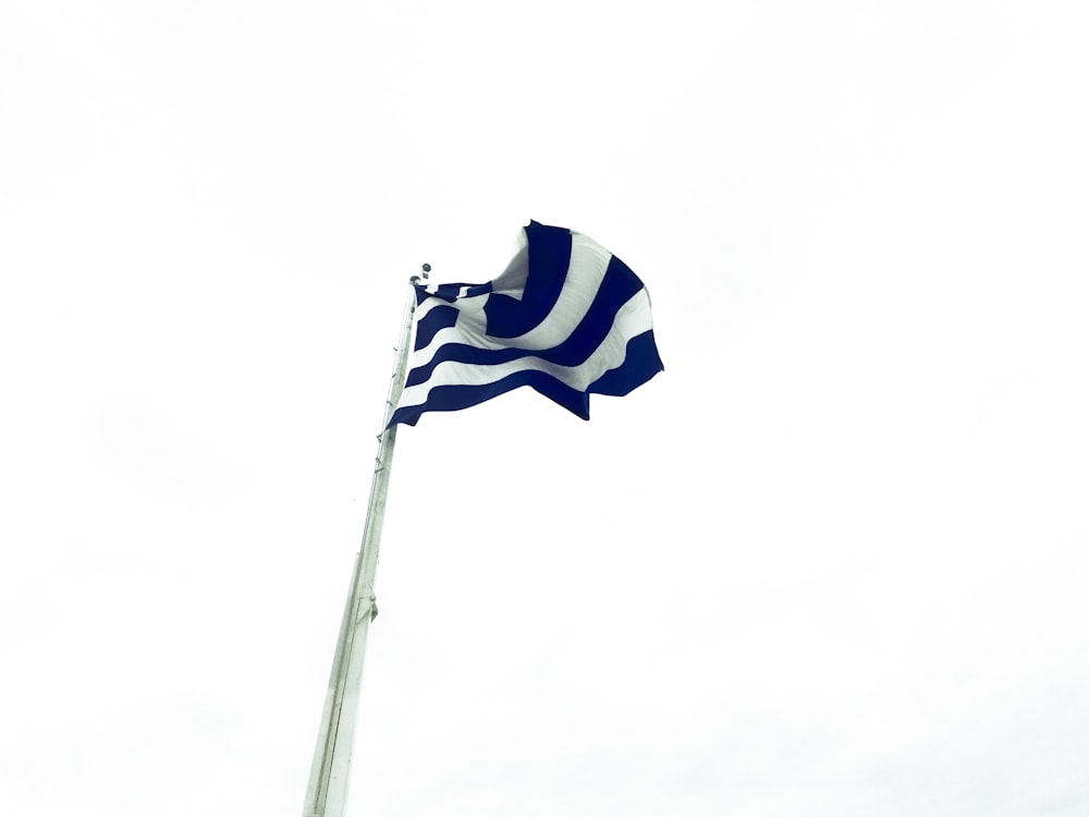 low angle photography of white and blue flag waving