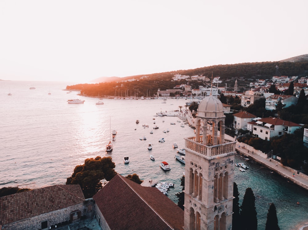 Photographie aérienne de maisons et de dômes près de la mer à l’heure dorée