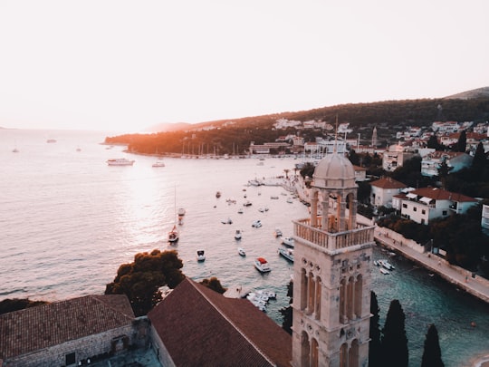 aerial photography of houses and dome building near sea at golden hour in Hvar Croatia