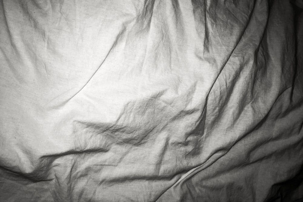 a black and white photo of an unmade bed