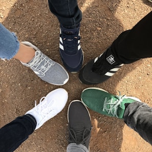 An overhead shot of running shoes arranged in a circle on a gym floor.