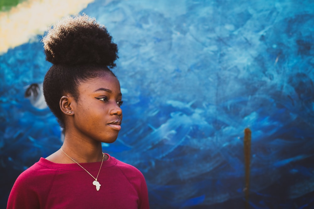 woman standing near blue concrete wall