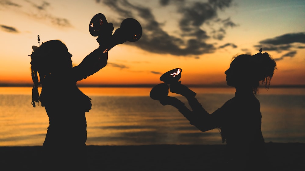 two women's silhouette near beach