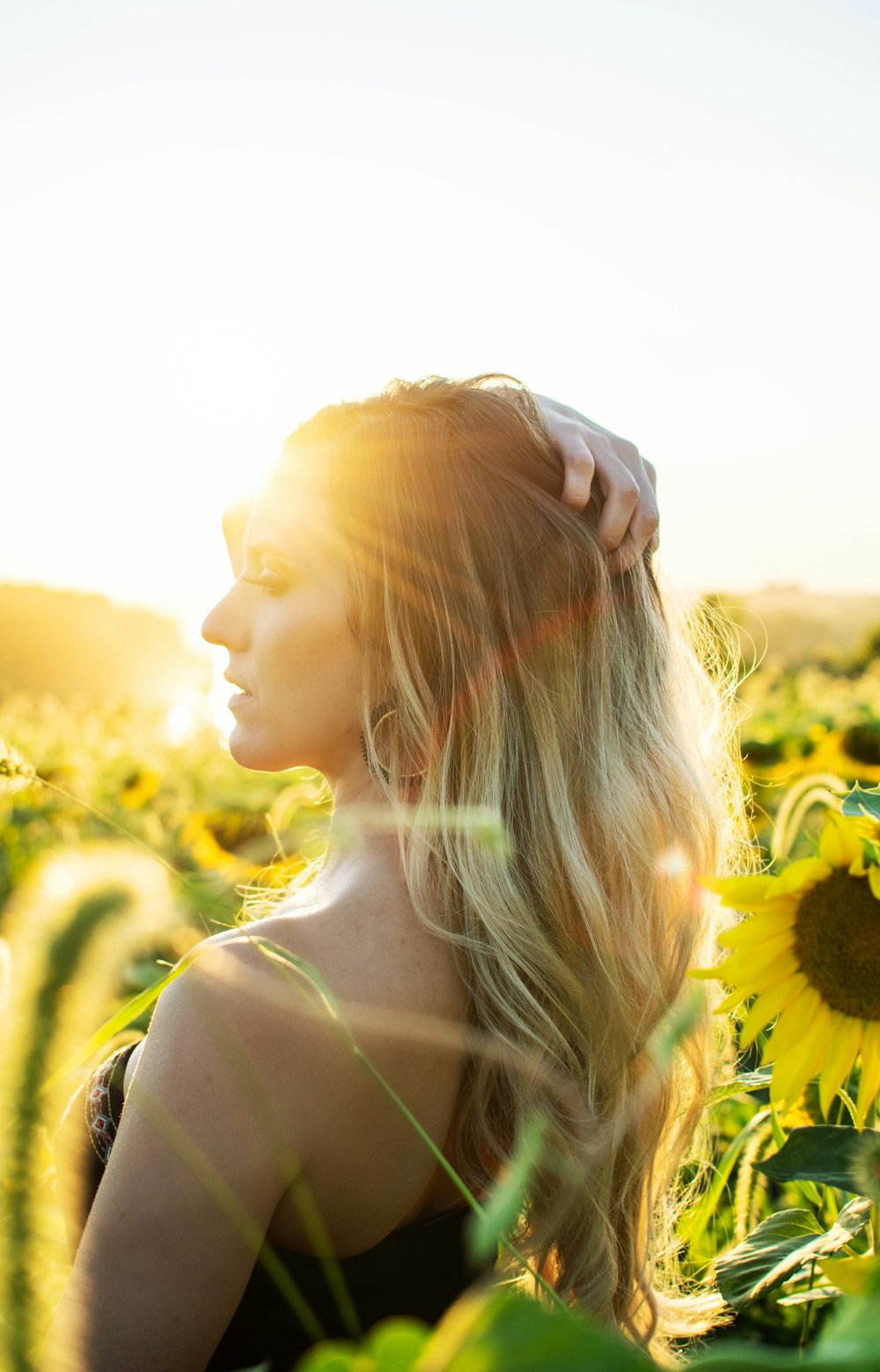 woman standing on sunflower field