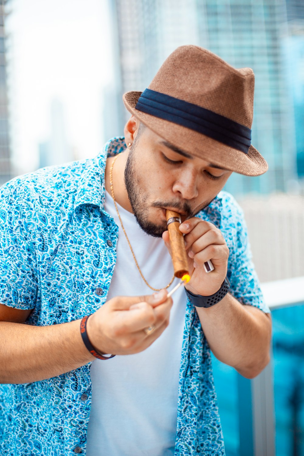 man lighting brown tobacco stick