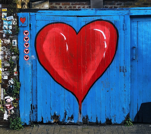 blue wooden gate with a red heart painted on it