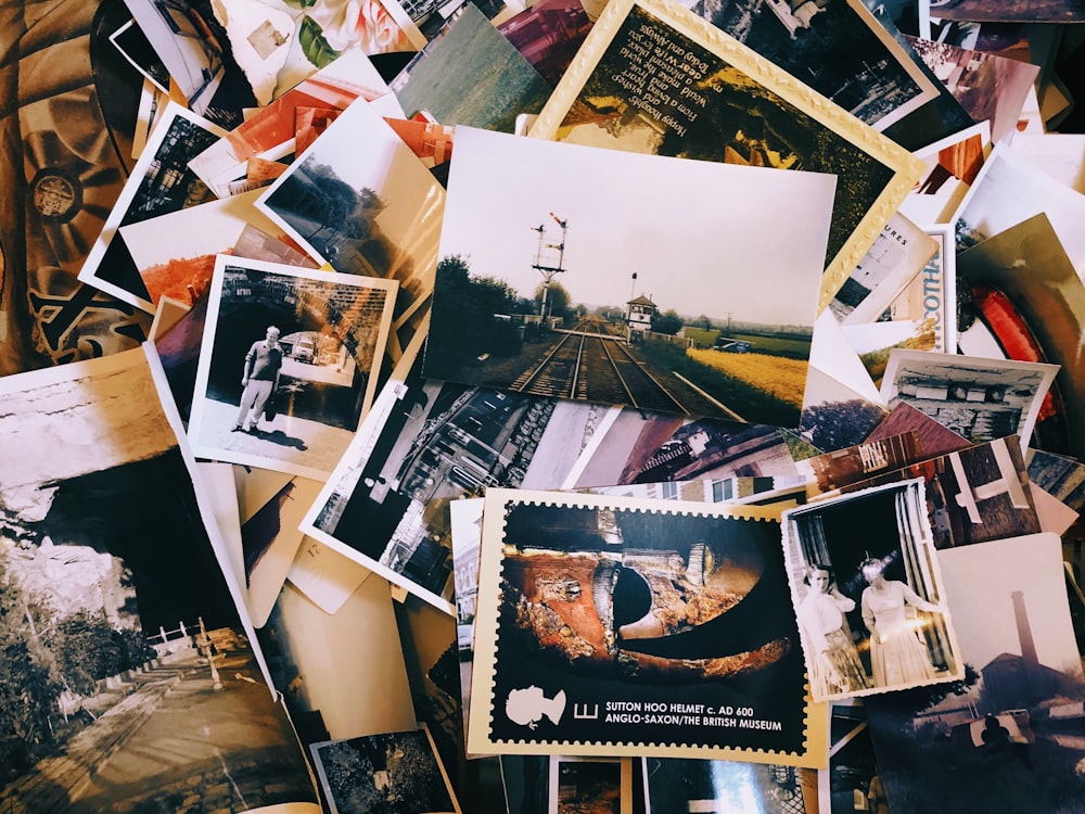 a pile of old photos and postcards sitting on top of each other