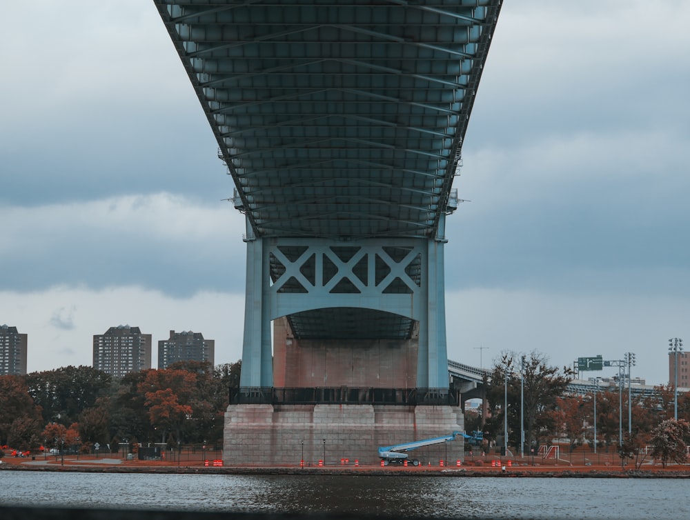 concrete bridge near city under white cloudy sky at daytime