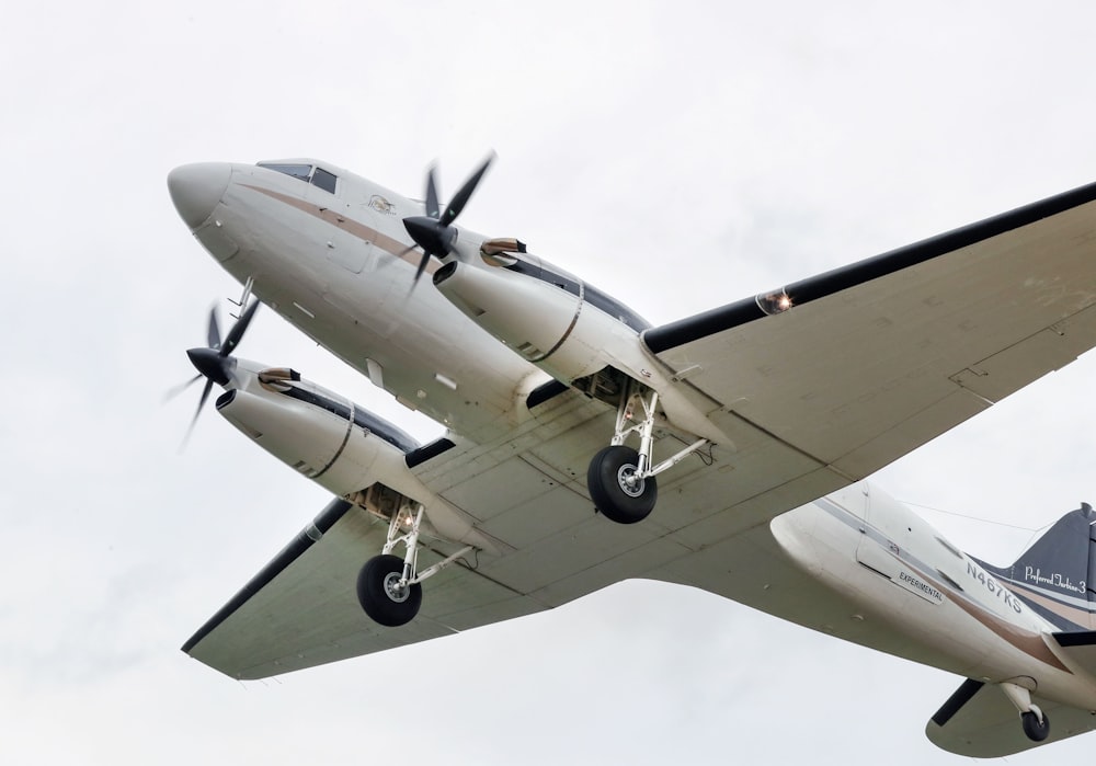 avion commercial volant sous un ciel blanc