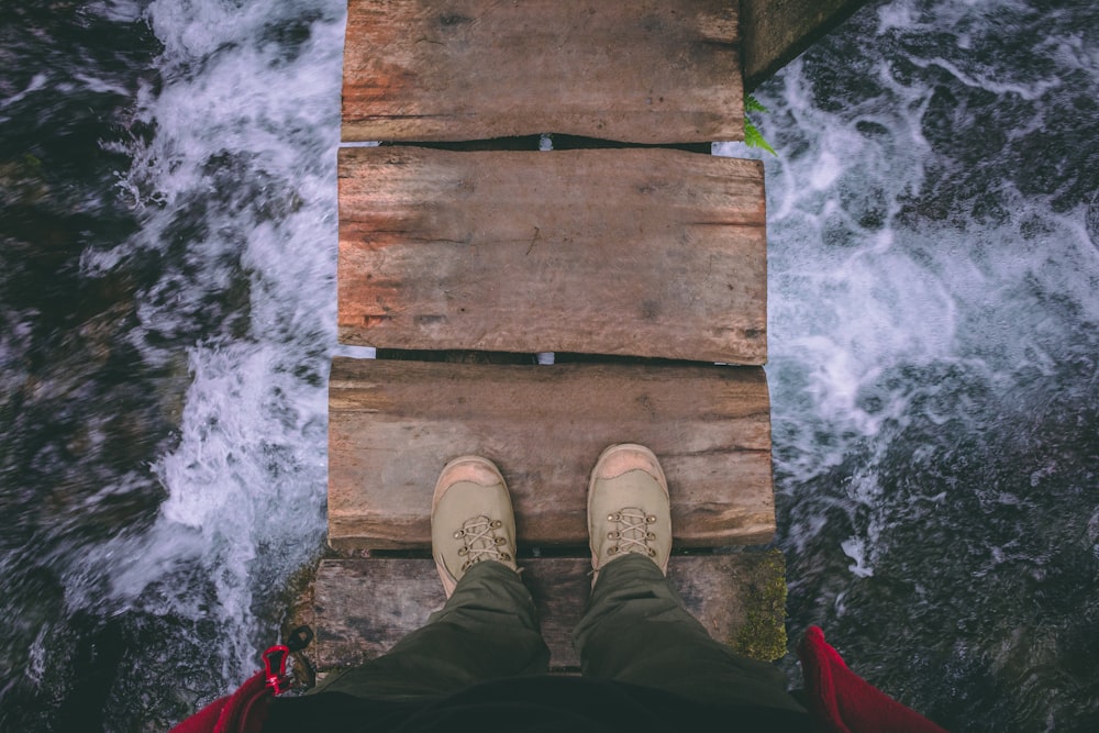 person standing on wooden bridge
