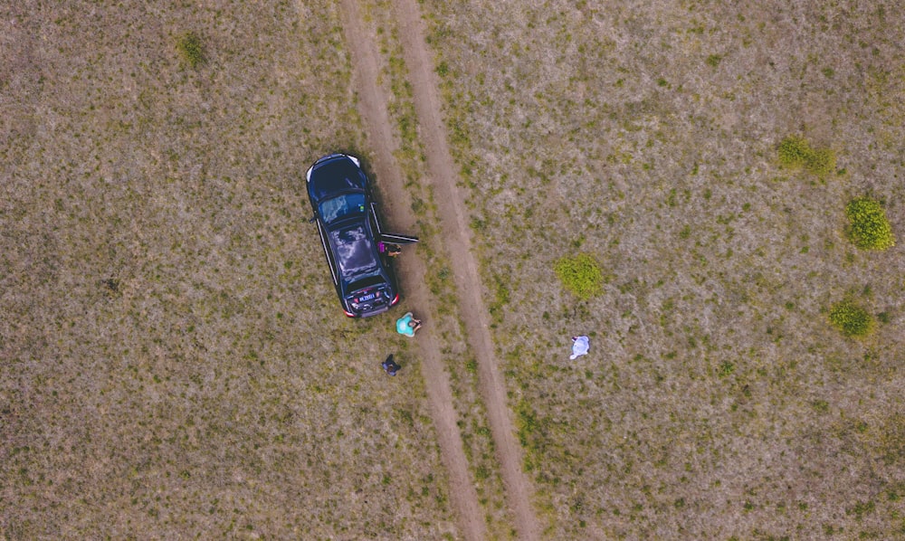 aerial photography of people near black car