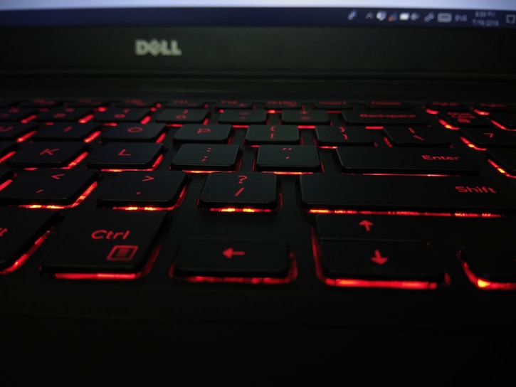 Close-up of a sleek Dell laptop keyboard illuminated by soft office lighting.