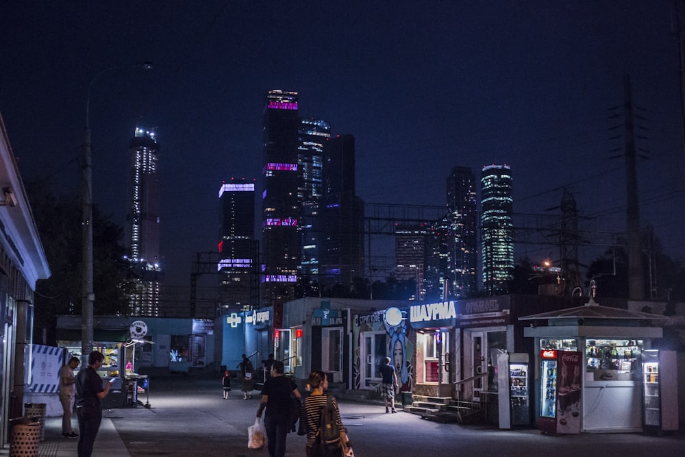 people walking on road between buildings