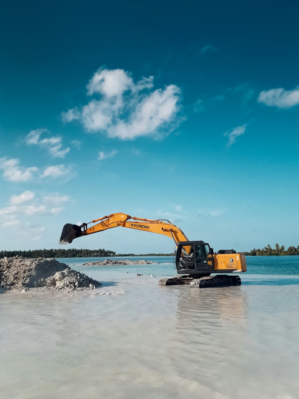 yellow excavator on seashore