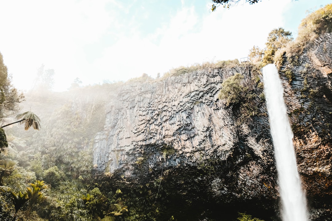 time lapse photography of falls from the cliff under white clouds