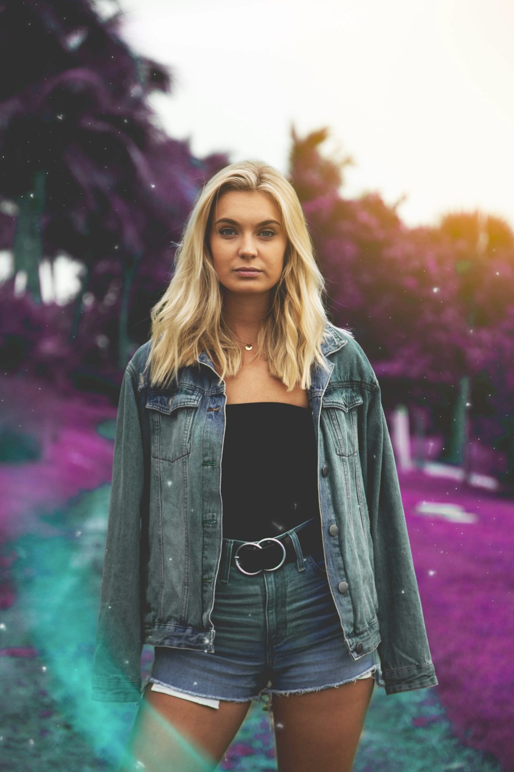 woman standing wearing denim jacket and short shorts