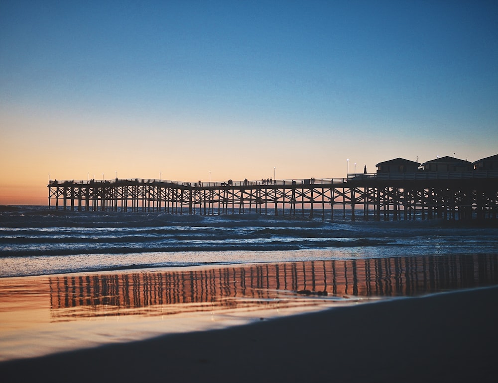 silhouette photo of houses on beach dock