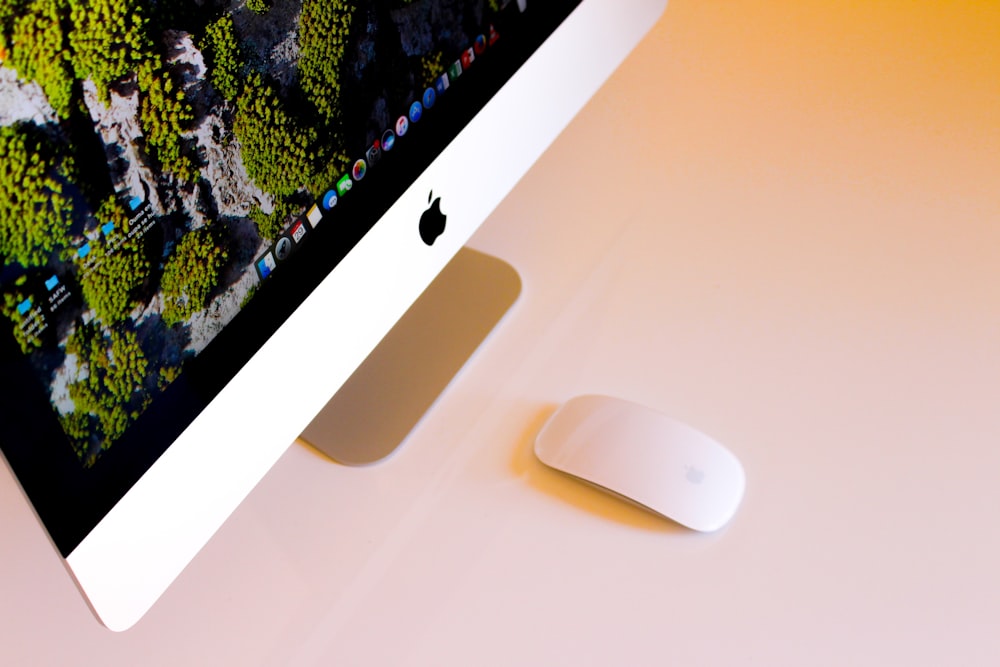 Apple Magic Mouse 옆에 켜진 은색 iMac