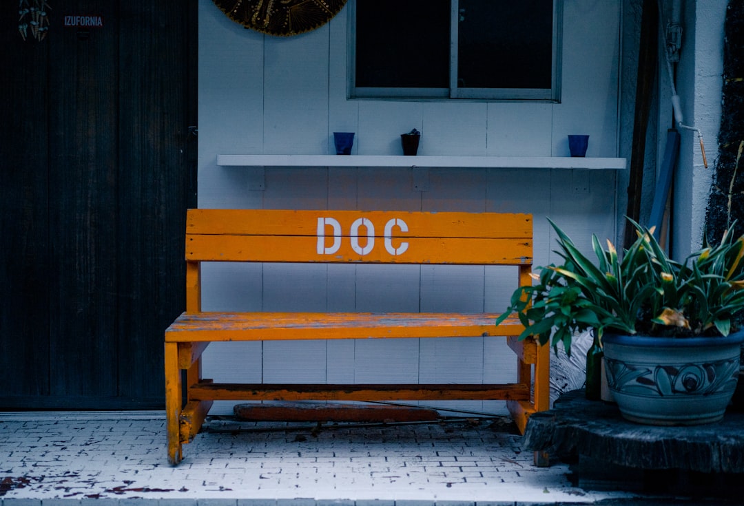 wooden bench placed outdoor below window