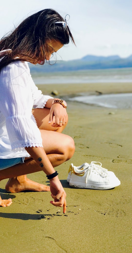 woman about to write on the sand at daytime in Barmouth United Kingdom