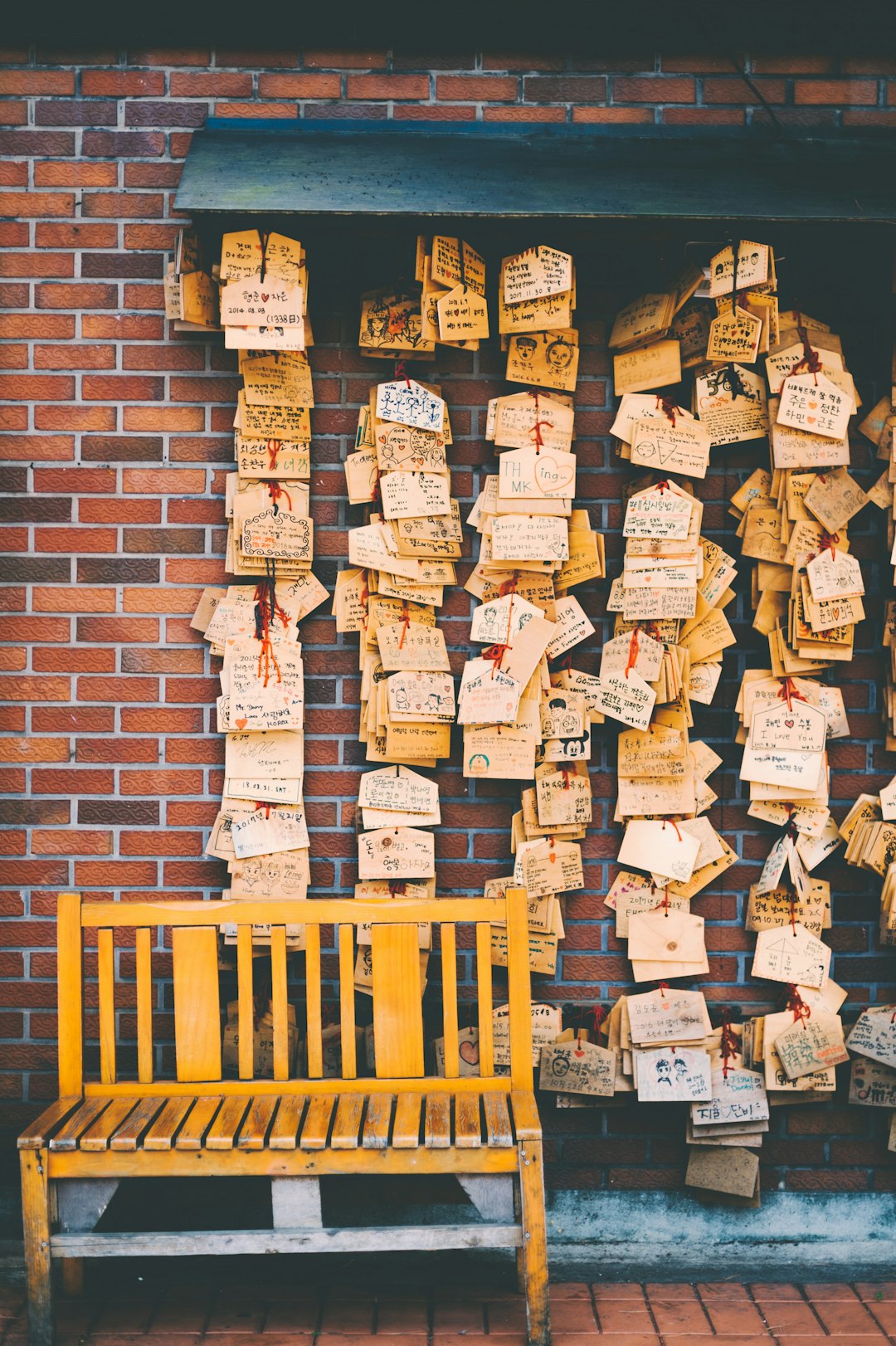 brown wooden bench in front of hanging cards