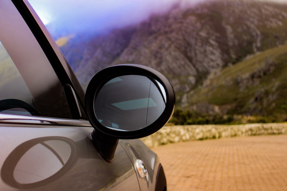 Selektive Fokusfotografie des silbernen Autos in Richtung Berg