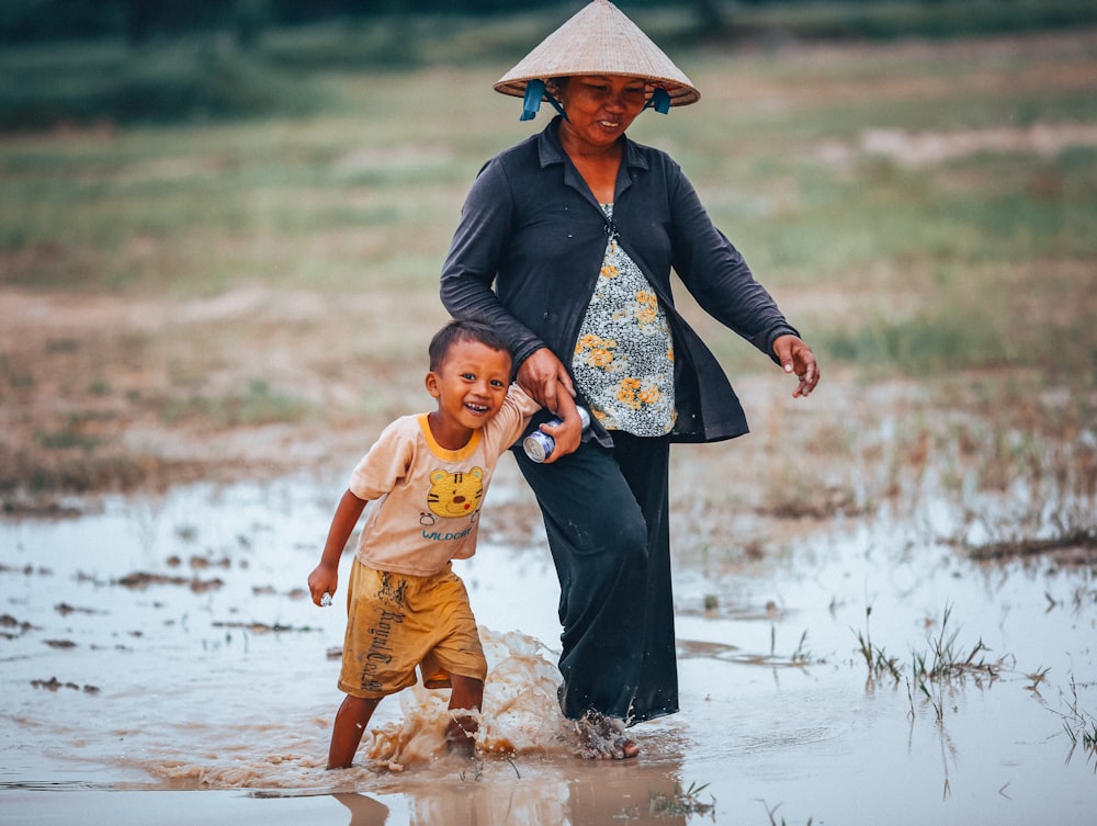 Mujer y niño caminando sobre arrozal