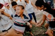 A group of children laughing and playing in casual outfits at a playground.