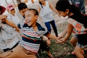 Children laughing and playing a playful board game outdoors.