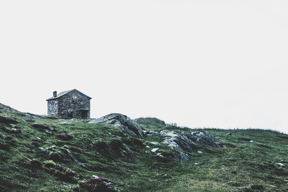 Casa de hormigón gris en montaña verde