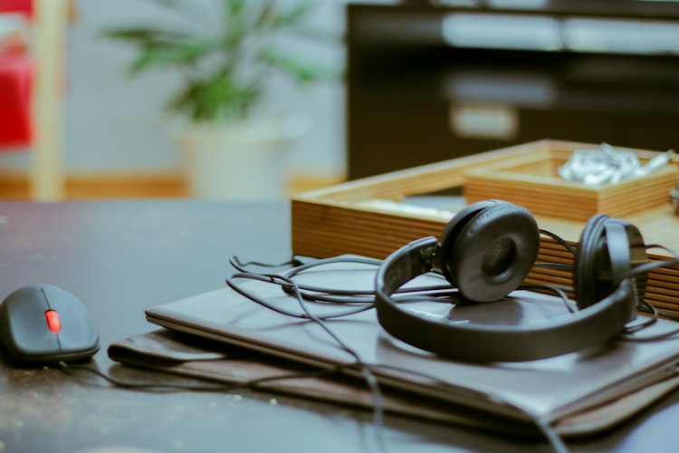Office headset on a laptop beside a mouse and desk accessories