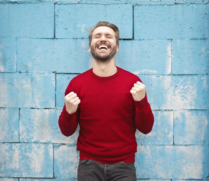 Person celebrating success with arms raised at sunrise
