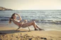 A smiling woman enjoying a sunny beach vacation.