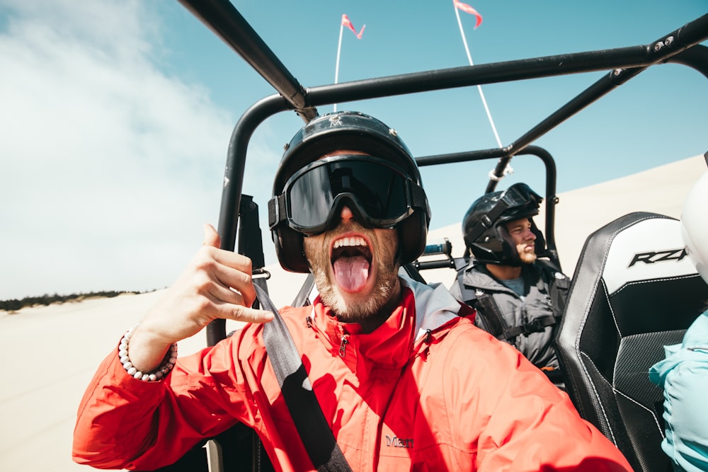 Mann zeigt seine Zunge während der Fahrt auf dem ATV