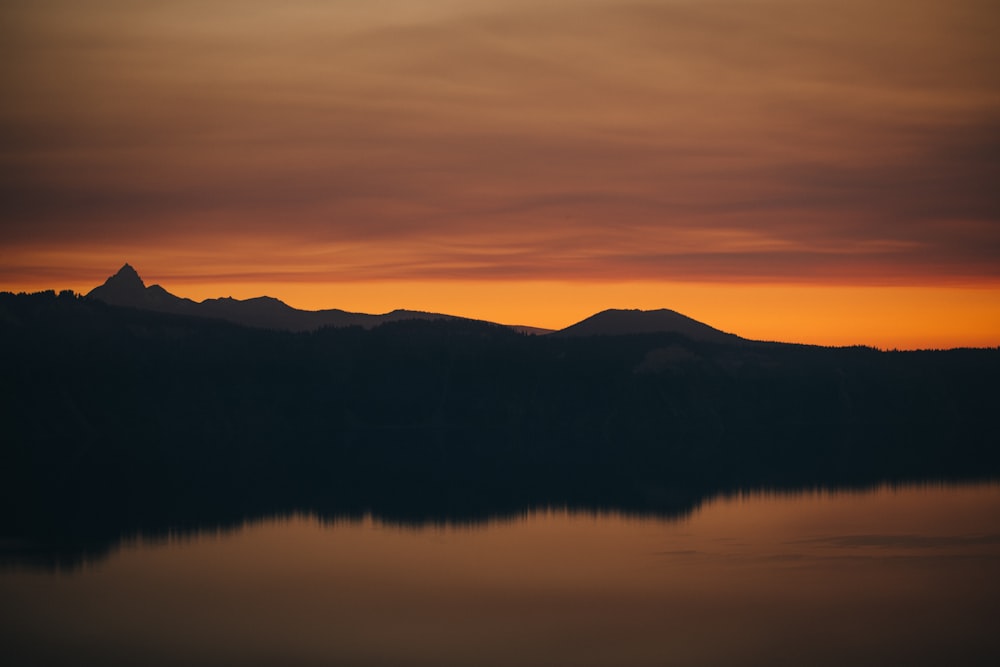 silhouette of mountains near body of water