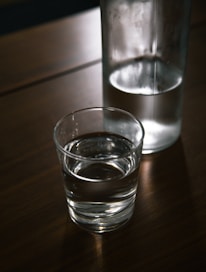 A clear bottle of purified water placed on a wooden table.