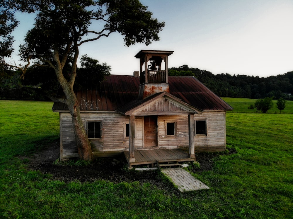 Baum neben brauner Holzhütte