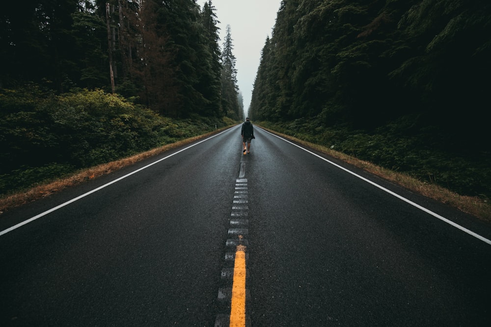 person walking alone in the middle of the road