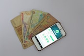 white Android smartphone beside banknotes
