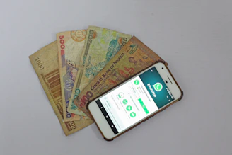 white Android smartphone beside banknotes