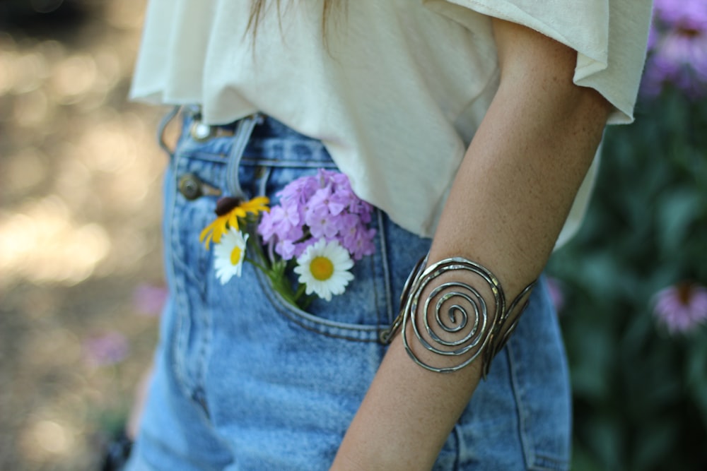 purple and white petaled flower in blue denim pocket